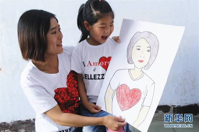 5月10日，在河北唐山市豐潤(rùn)區(qū)迎賓路幼兒園開(kāi)展的“媽媽，我愛(ài)你”主題活動(dòng)中，陳悅寧小朋友將自己的繪畫(huà)作品送給媽媽作為節(jié)日禮物。 新華社發(fā)（朱大勇 攝）