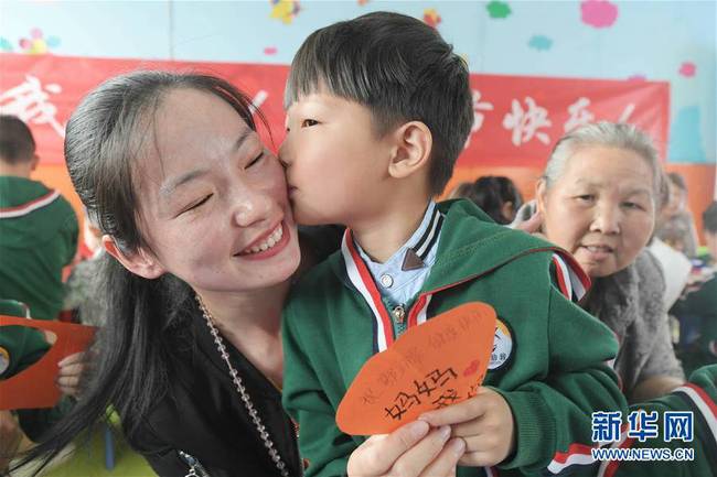 5月10日，在湖北省襄陽(yáng)市一家幼兒園舉辦的母親節(jié)主題活動(dòng)中，一名小朋友將自己制作的賀卡獻(xiàn)給媽媽。 新華社發(fā)（安富斌 攝）